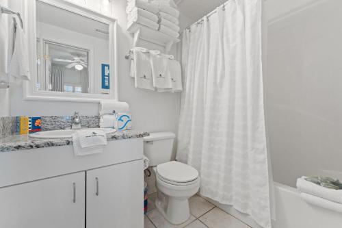 La salle de bains blanche est pourvue de toilettes et d'un lavabo. dans l'établissement Tidewater 503, à Orange Beach