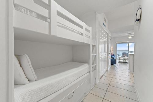 Tidewater 503 في شاطئ أورانج: غرفة نوم مع سرير بطابقين أبيض وأرضية من البلاط