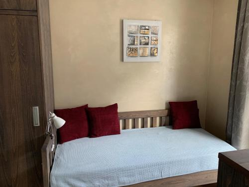 a small bedroom with a bed with red pillows at Haus Lothringen, TOP 8 in Bad Gastein