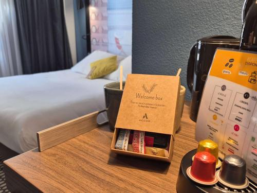 a hotel room with a welcome box on a table at Mercure Bordeaux Centre Ville in Bordeaux