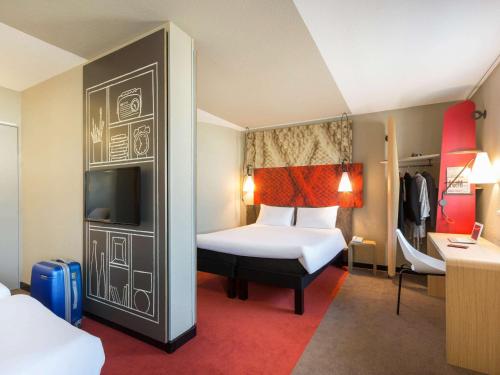 Habitación de hotel con 1 dormitorio con 1 cama y TV en Hotel ibis Rennes Centre Gare Sud en Rennes
