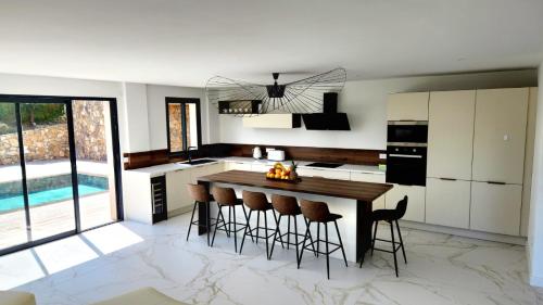 - une cuisine avec une table et des tabourets en bois dans l'établissement Villa Alina, un havre de paix, à Cagnes-sur-Mer