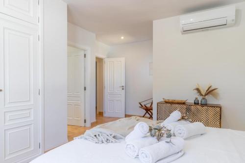 Un dormitorio blanco con toallas en una cama en Villa Rakhi 4, en Moraira