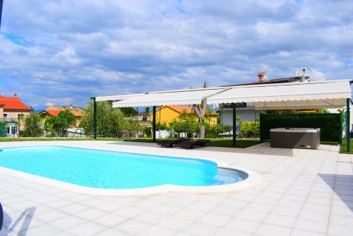 a swimming pool in a yard with a pavilion at Apartment Nika in Njivice