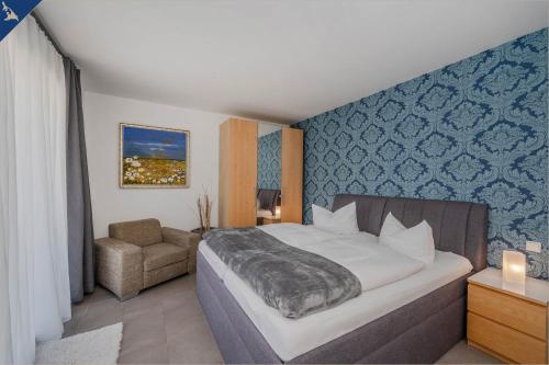 una camera con un grande letto e una sedia di Villen am See - Villa Petra Whg Bansin a Korswandt