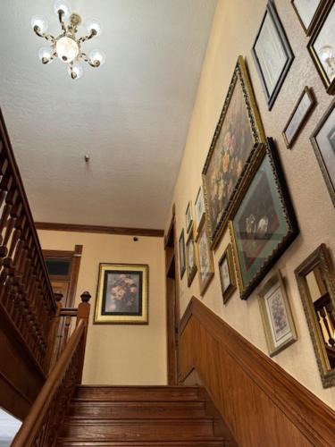 a hallway with stairs and pictures on the wall at Woodbine Inn and Restaurant in Madisonville