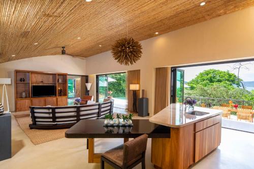 Culebra的住宿－哥斯達黎加帕帕加約半島度假村凱悅概念安達仕酒店，开放式厨房以及带桌椅的客厅。