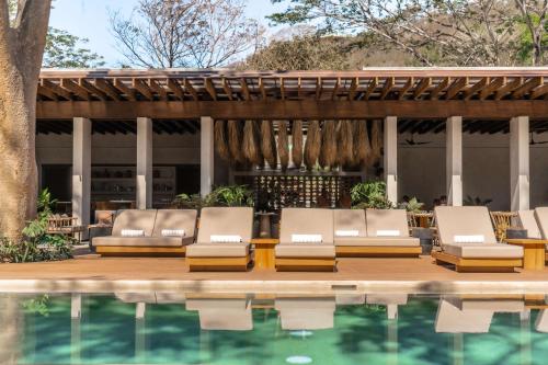 a group of lounge chairs next to a swimming pool at Andaz Costa Rica Resort at Peninsula Papagayo – A concept by Hyatt in Papagayo, Guanacaste