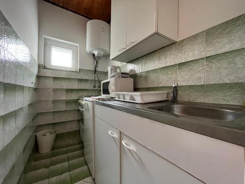 a kitchen with a sink and a counter top at Apartments Babić in Rab