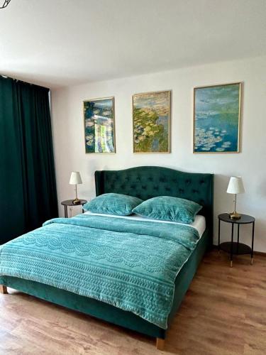 um quarto com uma cama verde com lençóis e almofadas azuis em Water Lily Apartment em Nivy
