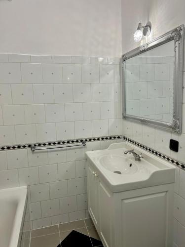uma casa de banho branca com um lavatório e um espelho em Water Lily Apartment em Nivy
