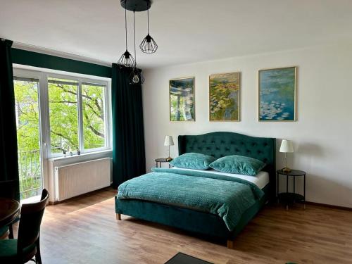 um quarto com uma cama verde e 2 janelas em Water Lily Apartment em Nivy