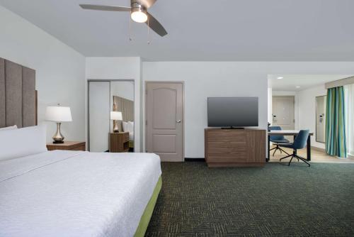 a hotel room with a bed and a flat screen tv at Homewood Suites by Hilton Davidson in Davidson