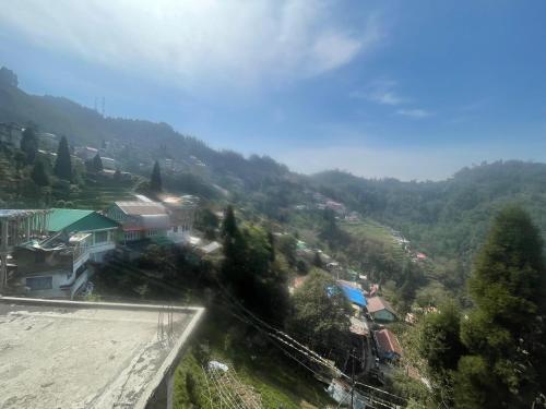 a view of a village in a valley with trees at Namo Sai Homestay in Darjeeling