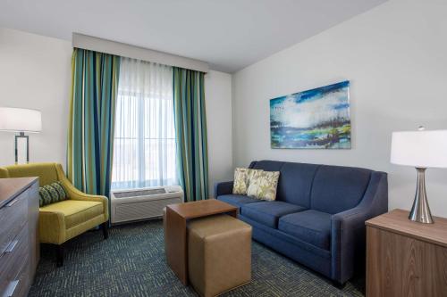 a living room with a blue couch and a chair at Homewood Suites by Hilton Davidson in Davidson