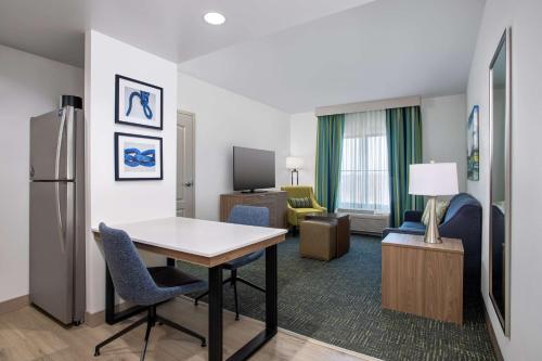 a hotel room with a table and chairs and a kitchen at Homewood Suites by Hilton Davidson in Davidson
