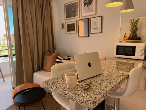 a living room with a table with a laptop on it at Stylish and comfortable one bedroom with sea view in Torremolinos