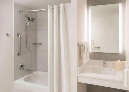 a white bathroom with a shower and a sink at Hilton Garden Inn Philadelphia Center City in Philadelphia