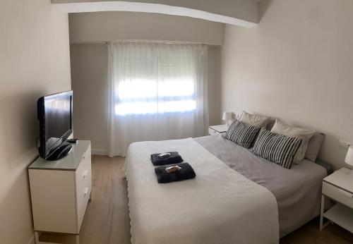Habitación blanca con cama y TV en Apartamento centrico familiar en Valencia( Frente Estacion Ave ,Joaquin Sorolla), en Valencia