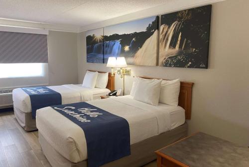 a hotel room with two beds and a window at Days Inn & Suites by Wyndham Arlington Heights in Arlington Heights