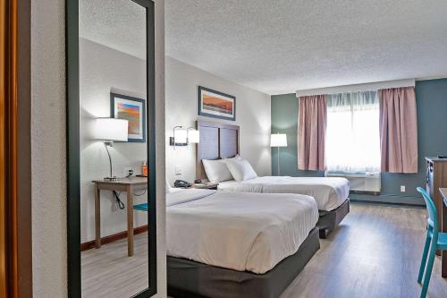 a hotel room with two beds and a mirror at Quality Inn Milan-Sandusky in Milan