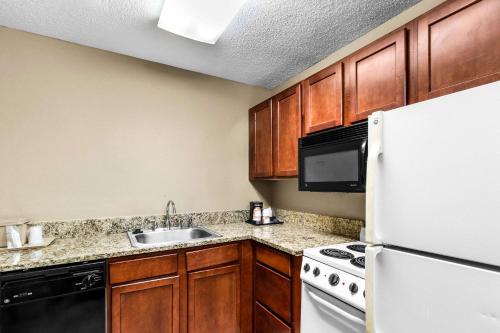 a kitchen with a sink and a white refrigerator at Comfort Inn Evansville East in Evansville