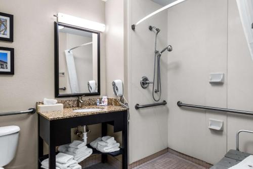 a bathroom with a sink and a toilet and a mirror at Comfort Inn Evansville East in Evansville