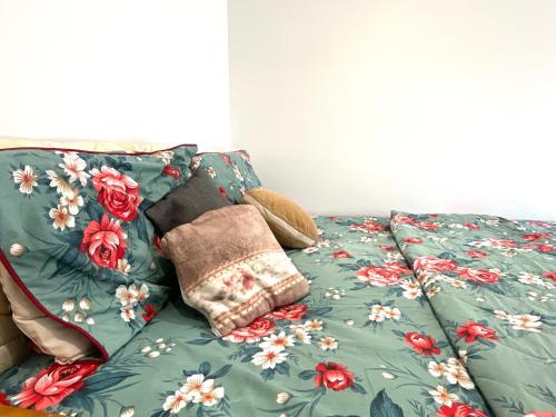- un lit avec une couverture verte et des fleurs dans l'établissement Spacious Relaxing Double Bedroom near Heart of City, à Birmingham