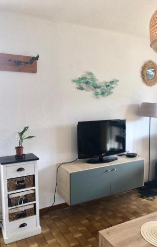 un salon avec une télévision à écran plat sur une armoire dans l'établissement T2 terrasse spacieuse belle vue résidence avec piscine, à La Croix-Valmer