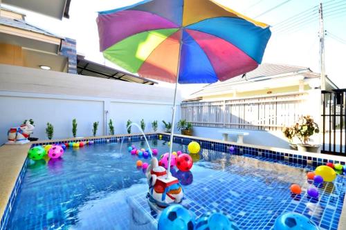 a pool with a colorful umbrella in a swimming pool at The Guestvilla644 in Hua Hin