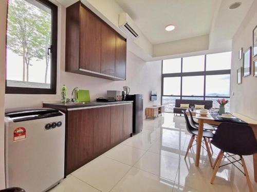 uma cozinha com um frigorífico e uma mesa com cadeiras em ICON City, Petaling Jaya em Petaling Jaya