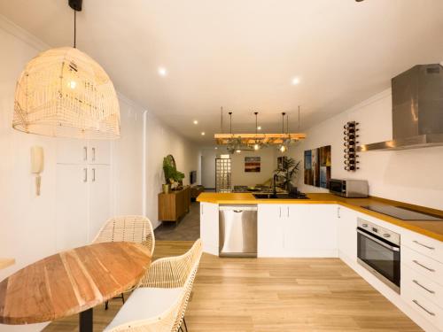 una cucina con mobili bianchi e un tavolo di legno di La Primera de Occidente a Cadice