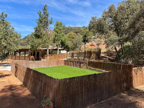 a retaining wall with a green lawn in front of a house at VILLAS LAS LAGUNAS 1 in Ossa de Montiel