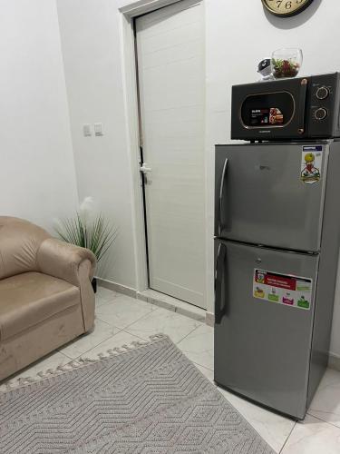 a room with a refrigerator with a microwave on top of it at 8 Luxury Studio in Abu Dhabi