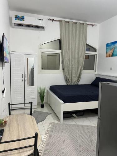 1 dormitorio con cama, escritorio y mesa en 8 Luxury Studio, en Abu Dabi