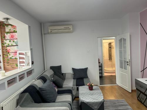 ein Wohnzimmer mit einem Sofa und einem Tisch in der Unterkunft Апартаменти Viviana in Plowdiw