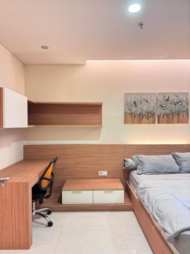Schlafzimmer mit einem Schreibtisch, einem Bett und einem Stuhl in der Unterkunft 2-bedroom apart near jiexpo with 6 bed & 2 bathroom in Jakarta