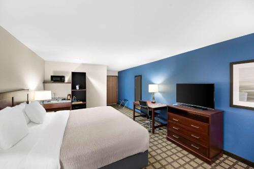 a hotel room with a bed and a flat screen tv at Quality Inn & Suites in Big Spring