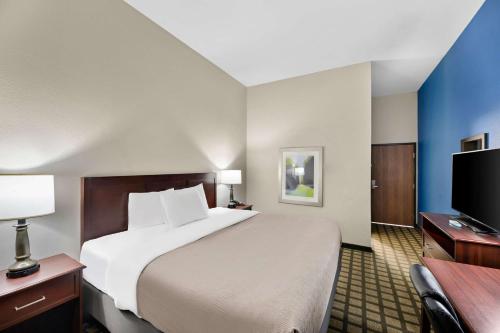 a hotel room with a bed and a flat screen tv at Quality Inn & Suites Big Spring in Big Spring
