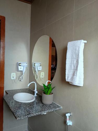 a bathroom with a sink and a mirror at FLAT 231 Shopping Amarração in Luis Correia