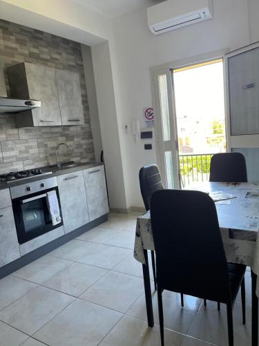 eine Küche mit einem Tisch und Stühlen im Zimmer in der Unterkunft Monolocale Rosy 2 in Porto