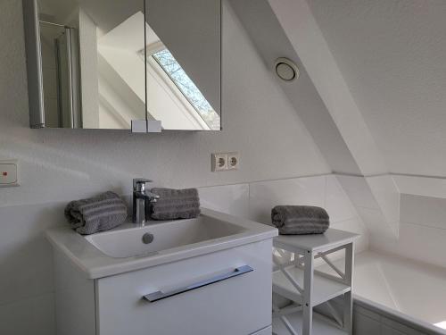 uma casa de banho com um lavatório e um espelho em Ferienhaus DHH "Unsere zweite Heimat" links em Sankt Peter-Ording