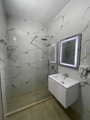 a white bathroom with a sink and a shower at Panorama Sea View Apartments in Vlorë