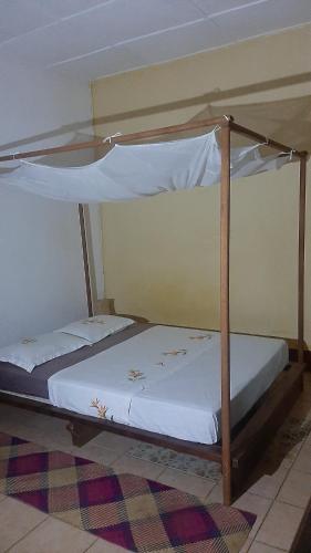 a bedroom with two bunk beds with white sheets at Les Alizés in Diego Suarez
