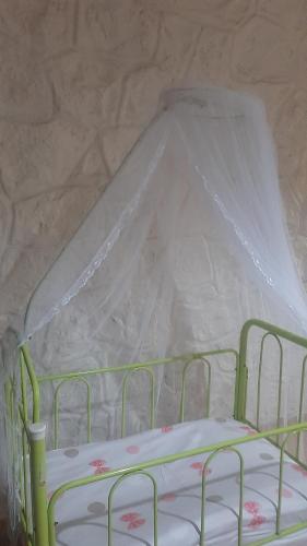 a green bed with a canopy in a room at Les Alizés in Diego Suarez