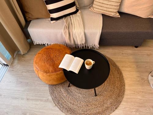 a coffee table with a book and a cup of coffee at Stylish and comfortable one bedroom with sea view in Torremolinos