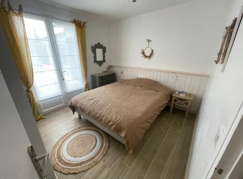 une chambre avec un lit, une table et une fenêtre dans l'établissement Saladjo, au Bois-Plage-en-Ré