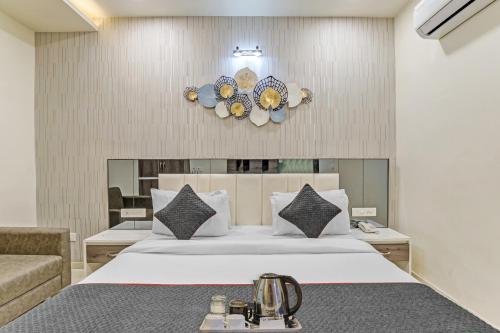 1 dormitorio con 1 cama blanca grande y 1 sofá en Hotel Park Seven Near Delhi International Airport, en Nueva Delhi