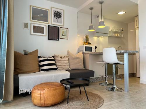 a living room with a couch and a table at Stylish and comfortable one bedroom with sea view in Torremolinos