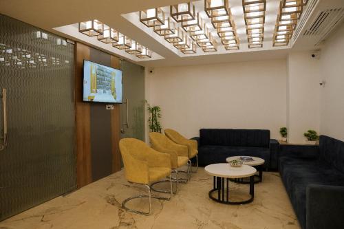 a living room with a couch and chairs and a table at Hotel The Grand in Indore